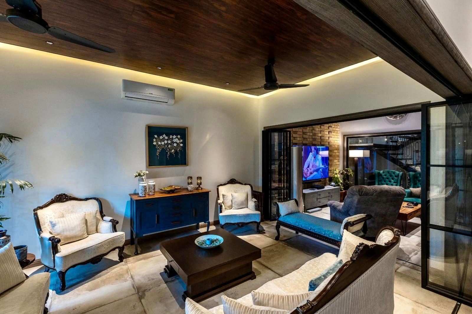 Elegant living room with vintage furniture, a blue cabinet, and a wooden ceiling.